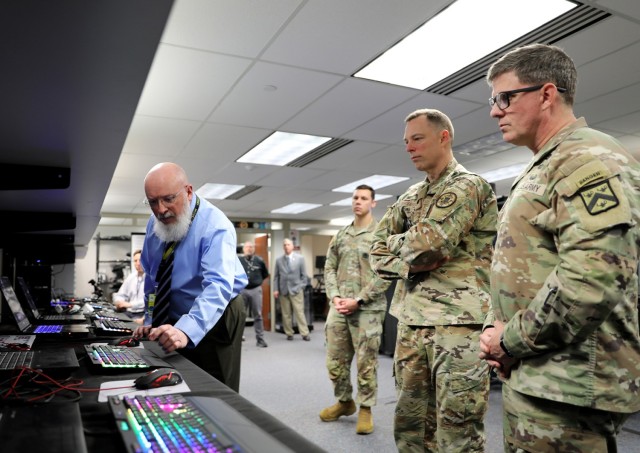 Hans Hull, Games for Training Capability Developer with the TRADOC Proponent Office-Synthetic Training Environment, explains a demonstration for Air Force Lt. Gen. Dagvin Anderson and Combined Arms Center-Training Deputy Commanding General Brig....