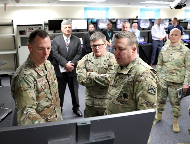 Air Force Lt. Gen. Dagvin Anderson and Combined Arms Center-Training Deputy Commanding General Brig. Gen. Jeremy Wilson listen to Staff Sgt. Bryan Davis explain the marksmanship training technology currently being evaluated at the Combined Arms...