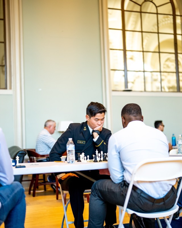 Staff Sgt. Imann A. Fletcher, facing away on the right, plays a Sicilian defense against a Sailor during the third round of the U.S. Armed Forces Chess Open at the United States Naval Academy.