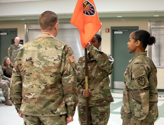 New 7th Signal Command (Theater) HHC First Sgt. Candice Bromell takes the guidon from Capt. Sophie Rosado, HHC Commander.