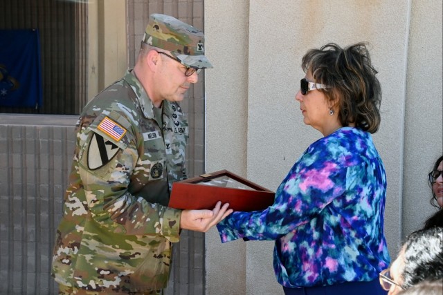 U.S. Army Yuma Proving Ground Commander Col. John Nelson (left) presents a flag flown over the Bracamonte Range Operations Center on March 12, late technical Director Larry Bracamonte&#39;s birthday, to Bracamonte’s widow Matilda Lugo (right) at...