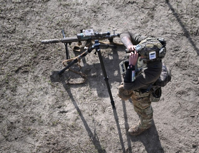 A competitor in the 16th Annual United States Army Special Operations Command International Sniper Competition looks through binoculars for long-distance targets on a range at Fort Bragg, North Carolina, March 19, 2025. Twenty-one teams competed...