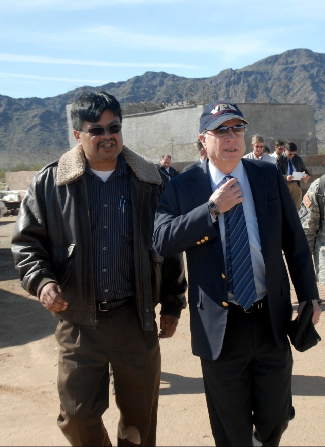 The late U.S. Army Yuma Proving Ground (YPG) Technical Director Larry Bracamonte (left) escorts the late Senator John McCain on a tour of YPG’s Joint Experimentation Range Complex in this 2010 photo. “I’m deeply impressed at the direct...