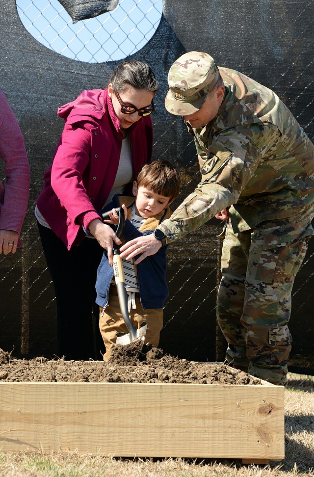 Representing Child Development Center patrons, Hedei and Maj. Christopher Newcomb, combat operations analyst at The Research and Analysis Center, and their 4-year-old son, Cortland, help break ground for the new CDC March 20, 2025, off Hancock...