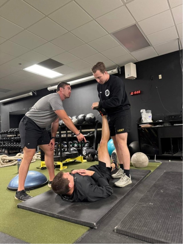 A 198th Infantry Brigade strength coach guides cadre members through stretching and mobility work during the Tactical Strength and Conditioning Facilitator Course (TSAC-F). (Photos courtesy of author)