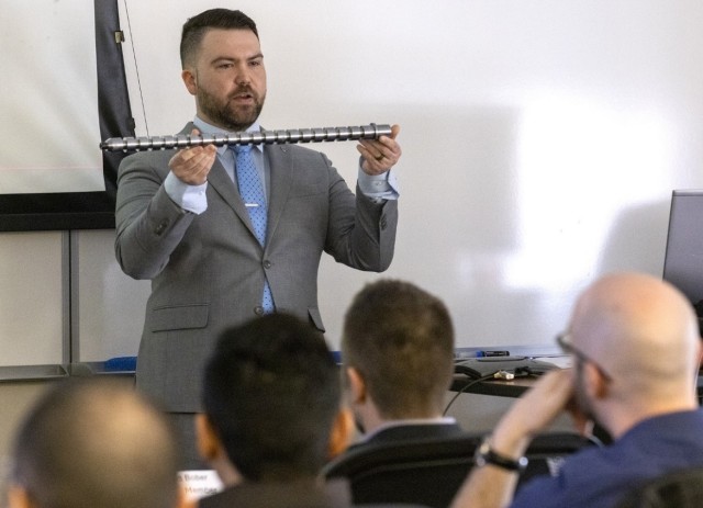 PICATINNY ARSENAL, N.J. - DEVCOM Armaments Center Engineer, Tyler Rotunno, holds a prototype barrel as he defends his doctoral research on the influence of barrel vibrations on weapon dispersion in his pursuit of a Doctor of Philosophy in Armament...