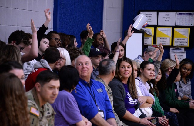 Children gathered for the Month of the Military Child kickoff ceremony raise their hands in response to how many times they have moved, ranging from three to eight moves in their lifetimes, during the MOMC kickoff ceremony and proclamation signing...