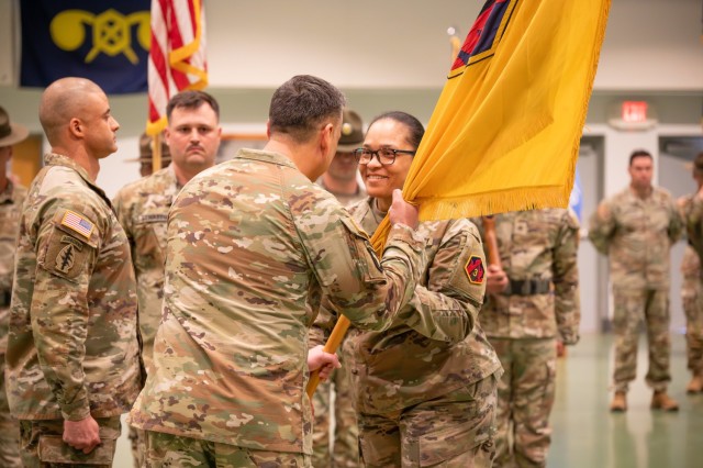 Outgoing Command Sgt. Maj. Kiana Bell relinquishes command of the 3rd Chemical Brigade by passing the brigade’s flag to Col. Hector Montemayor, 3rd Chemical Bde. commander, during a change of responsibility March 28 at Nutter Field House.