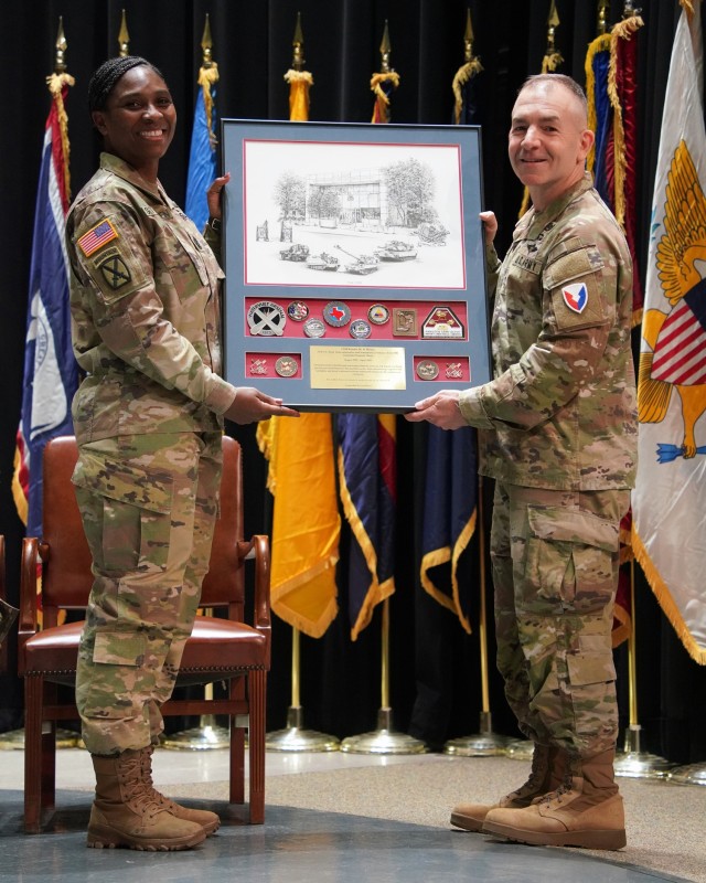 Command Sgt. Maj. Kendra St Helen receives a framed print and collection of coins from Maj. Gen. Michael B. Lalor, TACOM commanding general, at the April 2, 2025, Change of Responsibility ceremony.