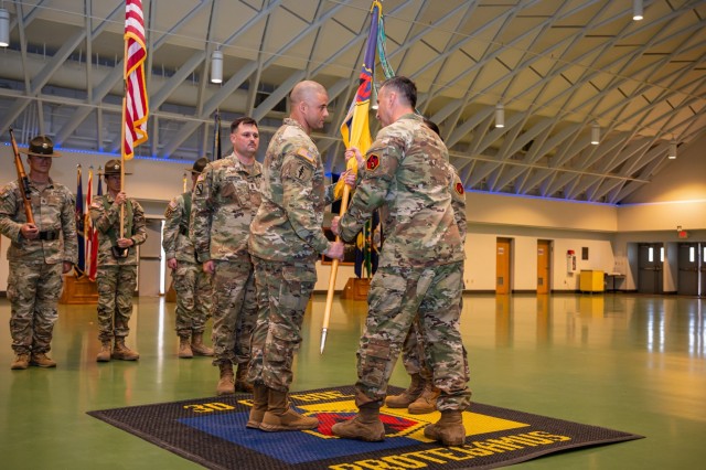 Incoming Command Sgt. Maj. Ronis Gutierrez takes the 3rd Chemical Brigade’s flag from Col. Hector Montemayor, 3rd Chemical Bde. commander, during a change of responsibility March 28 at Nutter Field House.