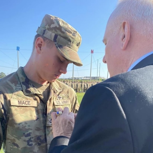 Retired Lt. Cmdr. Robert Mace pins airborne wings on his grandson, Pfc. Thor Mace, during Thor&#39;s airborne graduation at Fort Benning, Georgia, in September 2024.