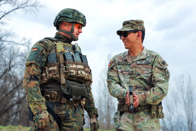 German Sgt. Maj. Thomas Vogel, German senior enlisted liaison to the U.S. Army Combined Arms Center, offers shooting form guidance to Sgt. Anthony Baltierra, Headquarters and Headquarters Company, Midwest Joint Regional Correctional Facility...