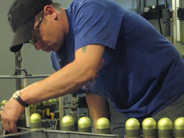 An employee at the Milan Army Ammunition Plant inspects 40mm rounds in this photo taken in May 2008.