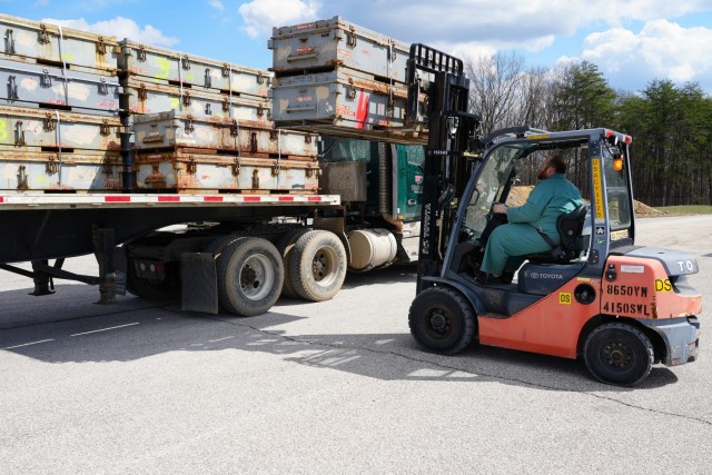Jason Roach, an ammunition specialist with Crane Army Ammunition Activity, loads empty steel munitions containers onto a truck bed for transport to a regional recycling center.