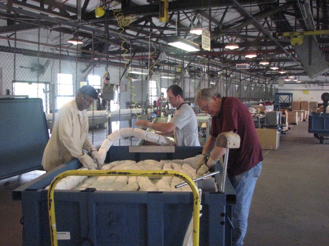 Employees at the Milan Army Ammunition Plant inspect 2,000 pounds of extruded C4 on a rope known as Mine-Clearing Line Charge (MICLIC) in this May 2008 photo.