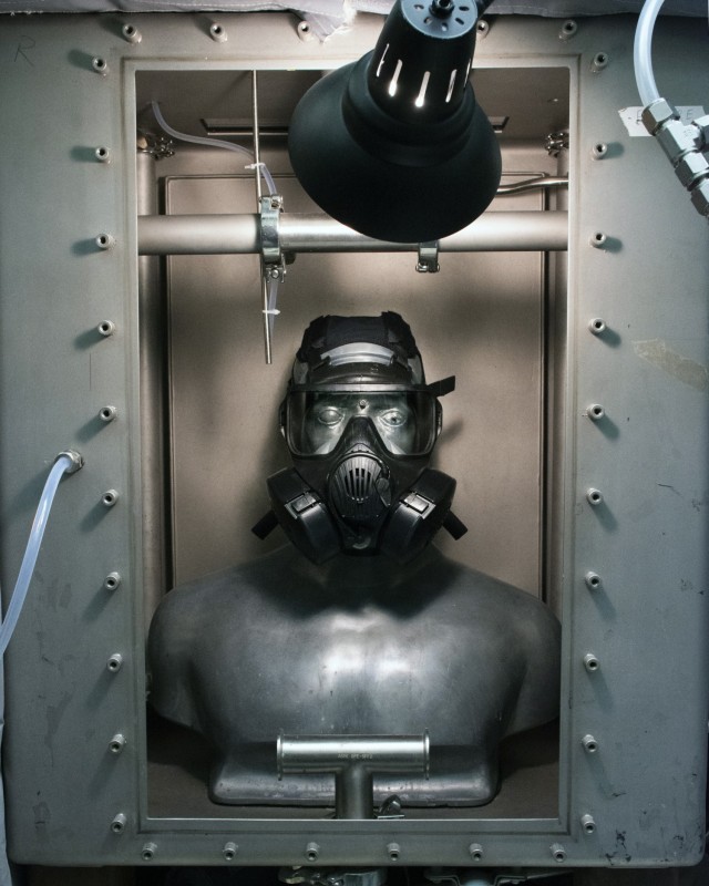 M50 gas mask affixed to SMARTMAN (Simulant Agent Resistance Test Mannikin) in small chamber, prior to challenging mask with Joint General Purpose Decontaminant for Hardened Military Equipment (JGPD HME). The test was conducted to learn whether the...