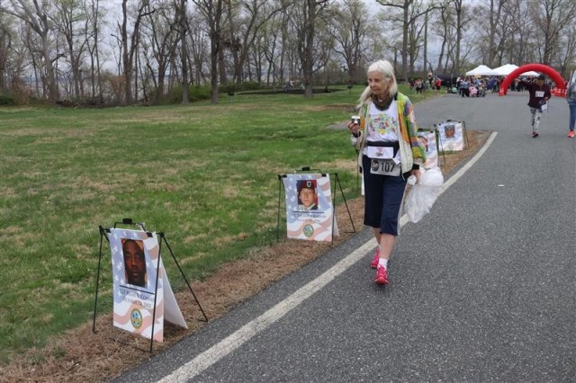 Military family member Carol Kemnitz, 78, views photos of fallen service members after the APG Run to Honor 5K on April 5, 2025.