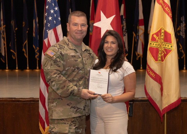 PICATINNY ARSENAL, N.J. - Maj. Gen. John T. Reim, Picatinny Arsenal Commanding General and Joint Program Executive Officer Armaments and Ammunition, presents a star-note congratulatory letter to Olivia Forsgren for her role in planning and...