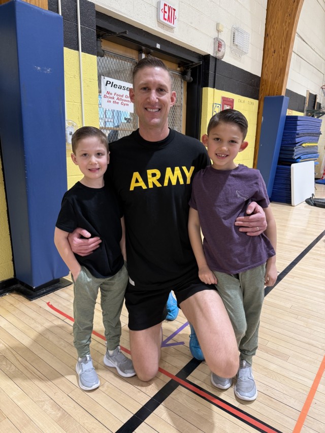 Maj. Eric Forsgren, Assistant Product Manager Small Arms Fire Control, Program Executive Office Soldier, (center) with his sons Jackson (left) and Maverick (right) during the school’s physical training exercise event.