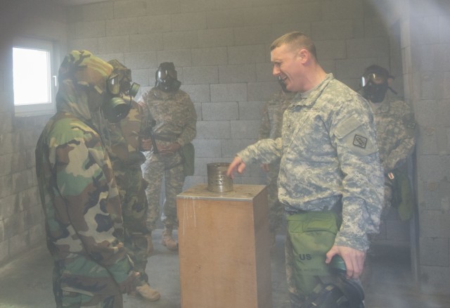 U.S. Army Sgt. Rusty Hilligoss, assigned to 128th Signal Company, 39th Signal Battalion, 2nd Signal Brigade, 5th Signal Command, answers questions without his M40 protective mask on in a cloud of CS gas as he trains on Chemical Biological...