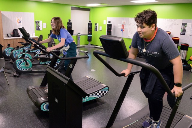 Eighth-graders Rachel Temple and Cooper Schmitdke watch on screen as they race against each other on treadmills while demonstrating use of the exergaming equipment April 17, 2025, at Patton Junior High School at Fort Leavenworth, Kansas. The...
