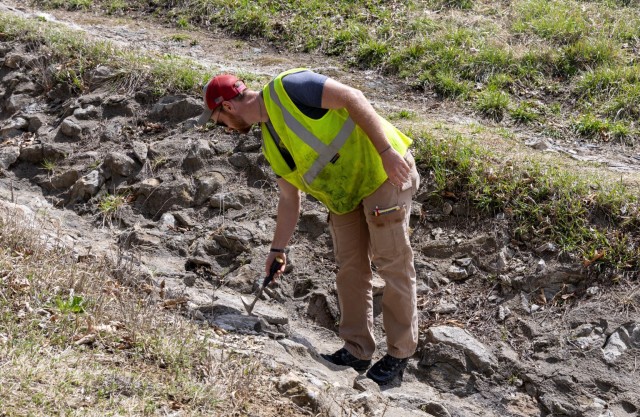 Geologist Tyler Fox inspecting the integrity of the grouted riprap on the upstream right abutment for Hillsdale reservoirs five-year periodic dam inspection.