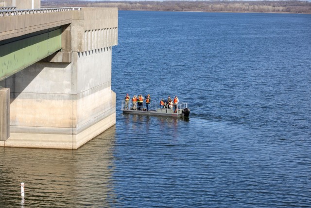 Several members of the Hillsdale Dam and reservoir five-year periodic inspection team taking a boat ride around the bridge and intake control tower structure to assess its condition.