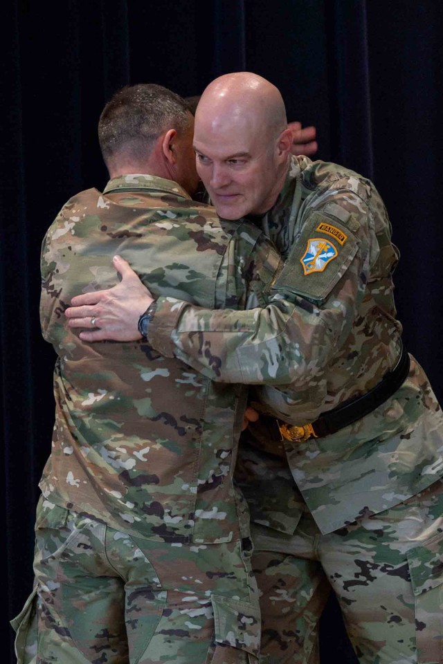 Brig. Gen. Rhett R. Cox, right, the commanding general of Army Counterintelligence Command, hugs Command Sgt. Maj. Craig M. Hood, left, the outgoing command sergeant major, at a change of responsibility ceremony at McGill Training Center, Fort...