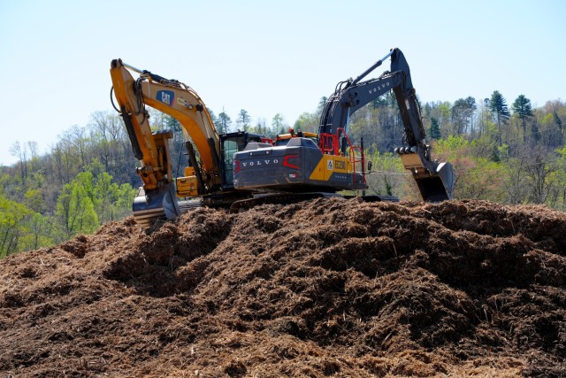 Two excavators sit atop a pile of mulched vegetative debris at the Old Fort Debris Management Site in Old Fort, North Carolina, April 9, 2025. The machines are staged to load mulch into tractor-trailers for disposal as part of Hurricane Helene...