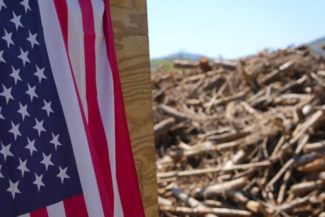 A portion of an American flag hangs outside the U.S. Army Corps of Engineers’ debris load inspection tower overlooking debris piles at the Old Fort Debris Management Site in Old Fort, North Carolina, April 9, 2025. The site plays a key role in...