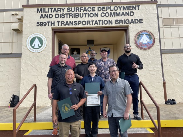 Rick Rodriguez and Kyle Buono, continuous process improvement instructors with SDDC, pose with Lean Six Sigma Green Belt course graduates at the 599th Transportation Brigade.
