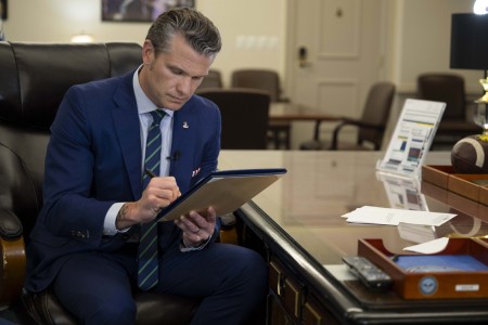 Defense Secretary Pete Hegseth signs a memorandum regarding medical waivers at the Pentagon, April 24, 2025.