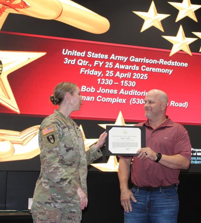Garrison Commander Col. Erin Eike presents an Officially Commended award to Brian Raney, of the Directorate of Public Works, during the quarterly awards ceremony April 25.