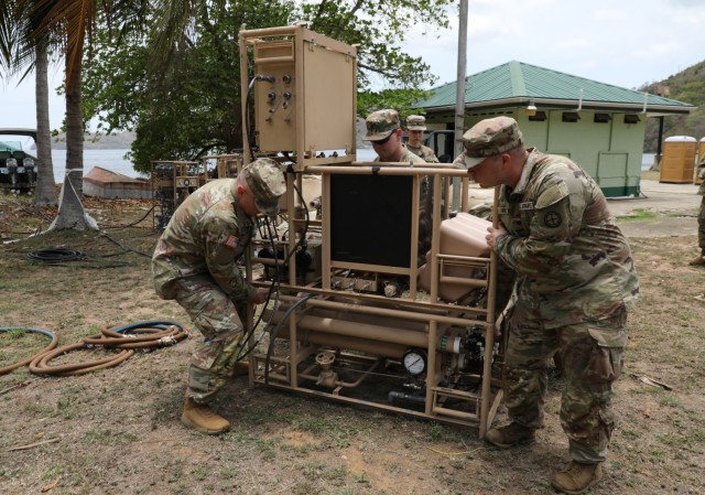 Left to right, Staff Sgt. Jeremy Simpson, Spc. Braxtyn Muncy and Spc. Colton Hines, water purification specialists with the 935th Aviation Support Battalion, Missouri Army National Guard stage a lightweight water purifier during TRADEWINDS 25...