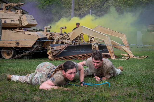 1st Lts. Megan Colpo and Jake Lanham, with the 3rd Armored Brigade Combat Team, 588th Brigade Engineer Battalion in Fort Carson, Colorado, maneuver under barbed wire during the 2025 Best Sapper Competition April 28 at Training Area 147.