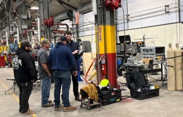A VRC employee trains Jose Ramirez, Terry Kennemore and Mike Bailey from the Metal Fabrication Branch on how to operate SIAD’s new VRC Dragonfly cold spray unit, located on the far right.