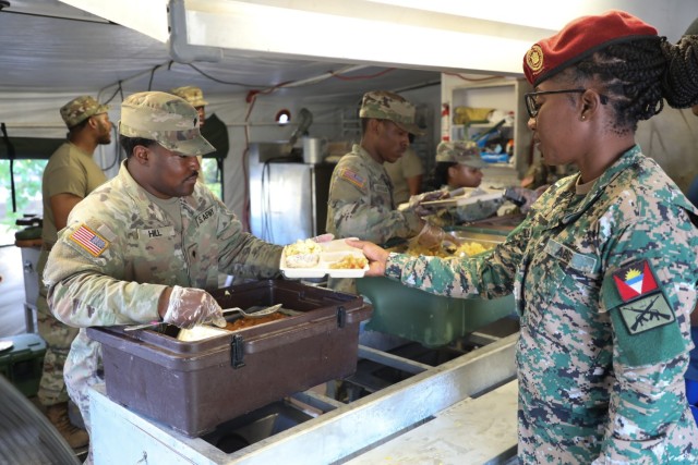 U.S Army Spc. Satchel Hill, left, a culinary specialist assigned to the 5001st Field Feeding Company, 167th Theater Sustainment Command, Alabama Army National Guard, serves breakfast to Antigua and Barbuda Defence Force Sgt. Tashika Riley during...