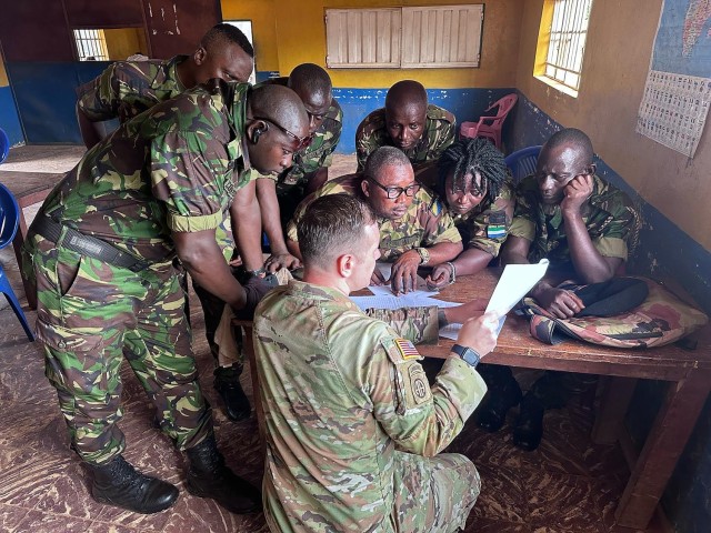 U.S. Army Sgt. 1st Class Shane Mills, readiness non-commissioned officer for the 246th Transportation Battalion, Michigan National Guard, discusses U.S. Army fleet management documentation processes with vehicle drivers from the Republic of Sierra...