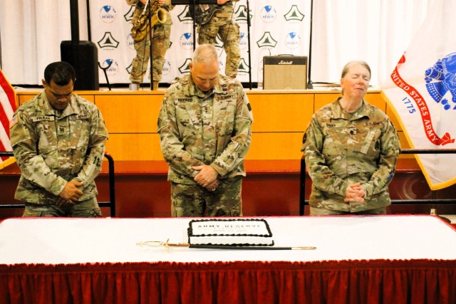 Fort McCoy’s Senior Commander, Maj. Gen. Joseph Ricciardi (center), commanding general of the 88th Readiness Division, and the oldest and youngest Soldiers attending the event prepare to cut the cake during the 2025 observance of the Army...