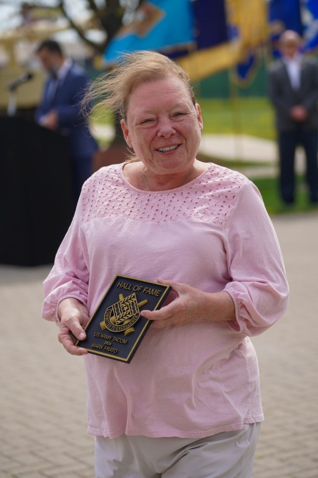 Sherry Frato, wife of the late Mark Frato, supervisor of the Provisioning Process Center, smiles after receiving an award on her husband&#39;s behalf at the TACOM Hall of Fame induction ceremony.