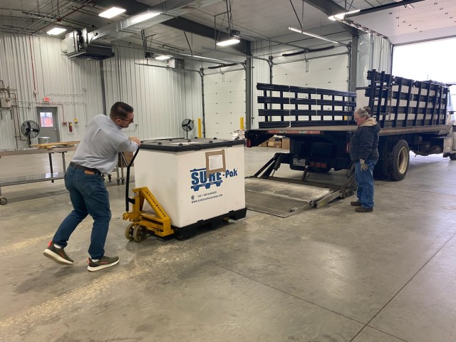 Information Technology Specialist Shawn Quinn and another employee move bins containing old phones March 4, 2025, in a warehouse building at Fort McCoy, Wis. Old phones were collected by the Fort McCoy Garrison Information Management Office after...