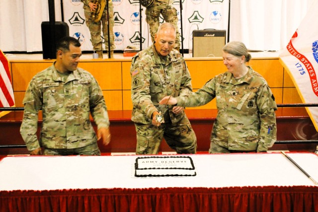 Fort McCoy’s Senior Commander, Maj. Gen. Joseph Ricciardi (center), commanding general of the 88th Readiness Division, and the oldest and youngest Soldiers attending the event prepare to cut the cake during the 2025 observance of the Army...