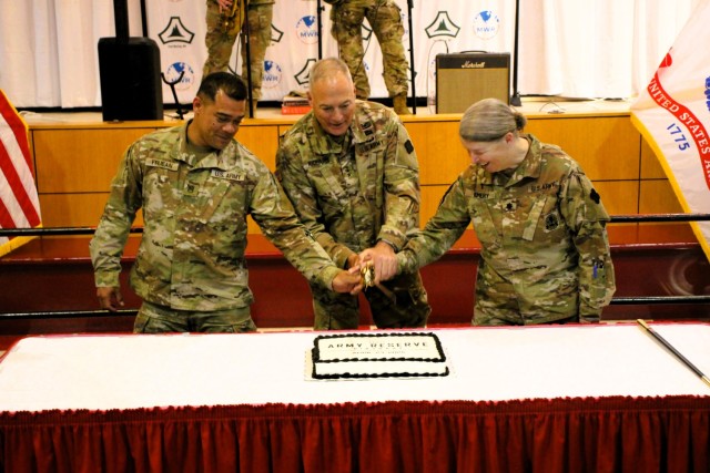 Fort McCoy’s Senior Commander, Maj. Gen. Joseph Ricciardi (center), commanding general of the 88th Readiness Division, and the oldest and youngest Soldiers attending the event prepare to cut the cake during the 2025 observance of the Army...