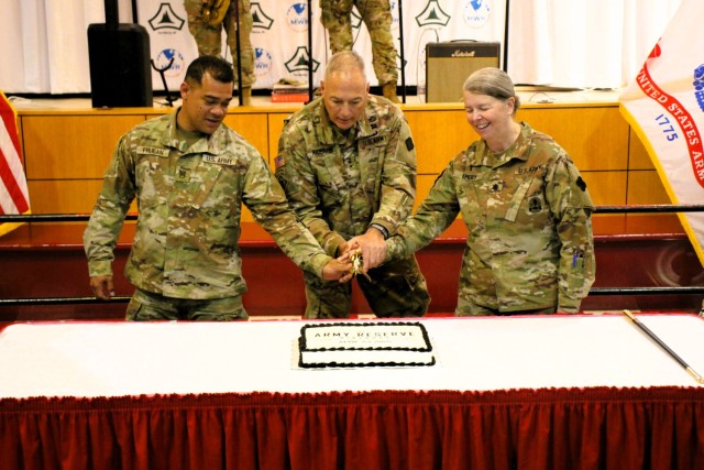 Fort McCoy’s Senior Commander, Maj. Gen. Joseph Ricciardi (center), commanding general of the 88th Readiness Division, and the oldest and youngest Soldiers attending the event prepare to cut the cake during the 2025 observance of the Army...