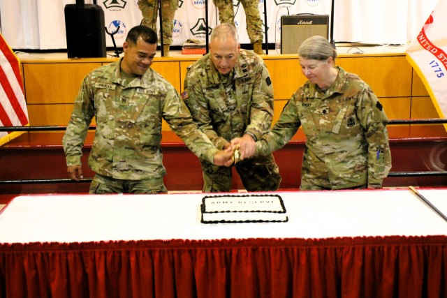 Fort McCoy’s Senior Commander, Maj. Gen. Joseph Ricciardi (center), commanding general of the 88th Readiness Division, and the oldest and youngest Soldiers attending the event prepare to cut the cake during the 2025 observance of the Army...