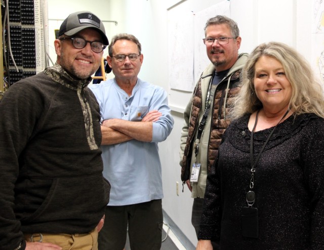 A&T employees stand alongside Fort McCoy Network Enterprise Cemter employee Kenneth O’Connell in the Dial Central Office on Nov. 21, 2024, at Fort McCoy, Wis. Their employees supported the decommissioned system and will continue to support the...