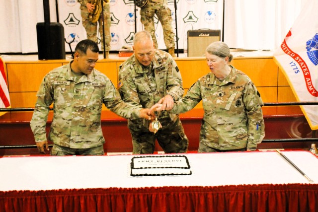 Fort McCoy’s Senior Commander, Maj. Gen. Joseph Ricciardi (center), commanding general of the 88th Readiness Division, and the oldest and youngest Soldiers attending the event prepare to cut the cake during the 2025 observance of the Army...