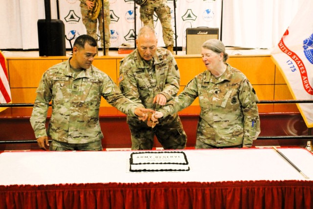 Fort McCoy’s Senior Commander, Maj. Gen. Joseph Ricciardi (center), commanding general of the 88th Readiness Division, and the oldest and youngest Soldiers attending the event prepare to cut the cake during the 2025 observance of the Army...