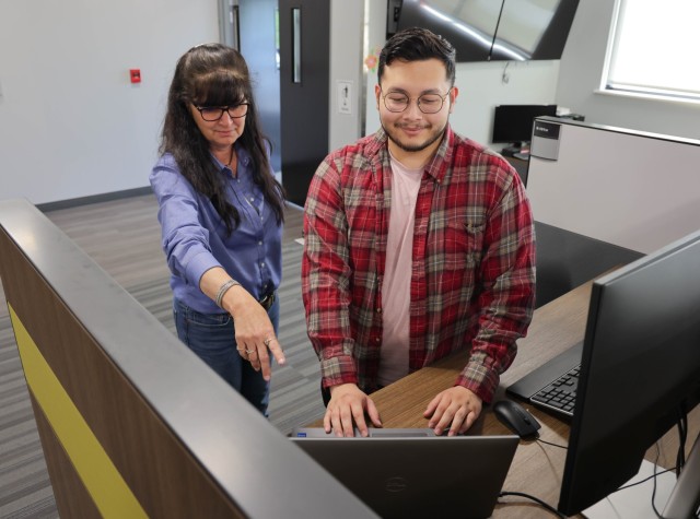 Stephano Paredes assists Kristina Maier Lyman with an IT issue; G6 members are now routinely meeting face to face with the workforce and by addressing many of the 5,000 monthly help desk tickets in person rather than remotely, they're building...