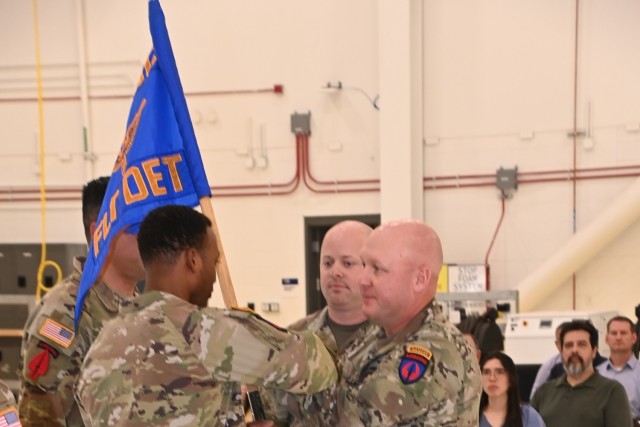 Chief Warrant Officer 5 Ryan Wells (right), new commander of the U.S. Army Special Operations Aviation Command Flight Detachment at Yuma Proving Ground, passes the guidon to Non-Commissioned Officer in Charge Sgt. 1st Class John McMichael on May...